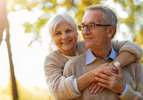 Elderly couple embracing in autumn park